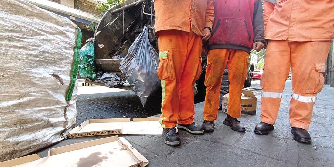 Tres trabajadores muestran sus uniformes adquiridos por cuenta propia, ayer.