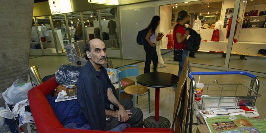 Merhan Karimi Nasseri se sienta entre sus pertenencias en la Terminal 1 del aeropuerto Roissy Charles De Gaulle, al norte de París, el 11 de agosto de 2004