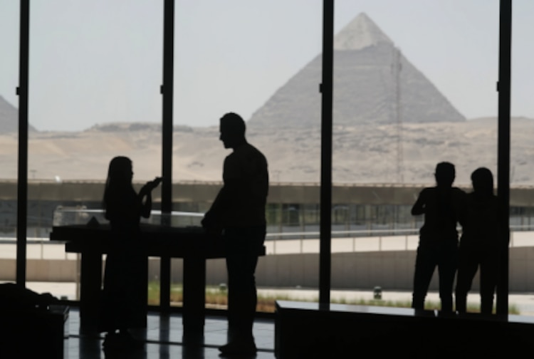 Turistas ven el sitio de las grandes pirámides desde la zona de descanso del Gran Museo Egipcio en Giza, Egipto, el viernes 23 de mayo de 2025.