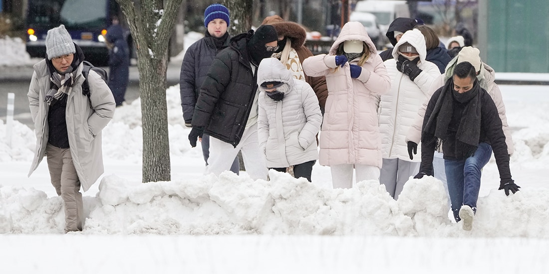 Peatones caminan entre la nieve acumulada ayer en calles de Nueva York.