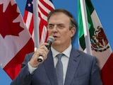 Marcelo Ebrard, secretario de Economía, con banderas de México, Estados Unidos y Canadá al fondo.