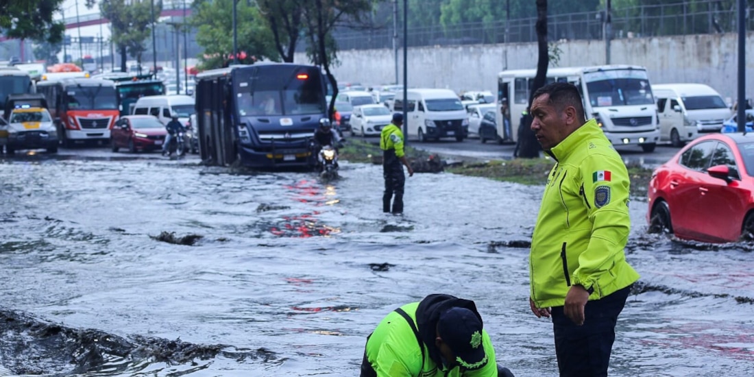Dos policías trabajan para abrir una coladera en la Calzada Zaragoza, ayer.