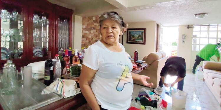 La familia de Graciela lleva a cabo labores de limpieza, este lunes.