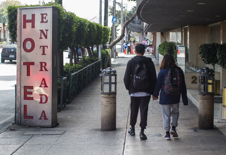 Dos jóvenes caminan frente a un hotel ubicado en Tlalpan.