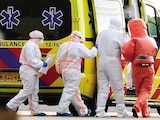 Personal médico acompaña a paciente evacuado del crucero en Ámsterdam, ayer.