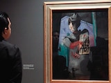 Un hombre admira una pintura de Cantinflas de Rufino Tamayo