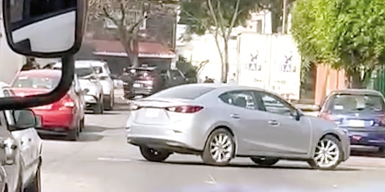 A LA DISTANCIA, otros tiradores se esconden detrás de una camioneta negra.