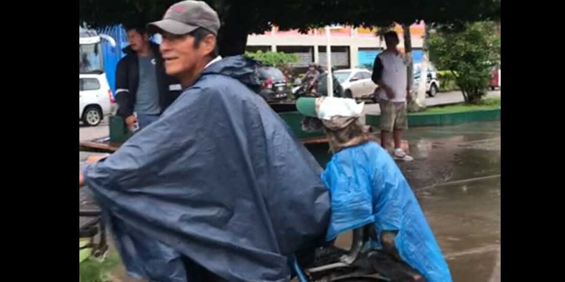 Hombre coloca bolsa a 'lomito' para que no se moje con la lluvia