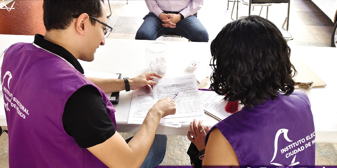 Personal del IECM revisa documentos, en una fotografía ilustrativa.