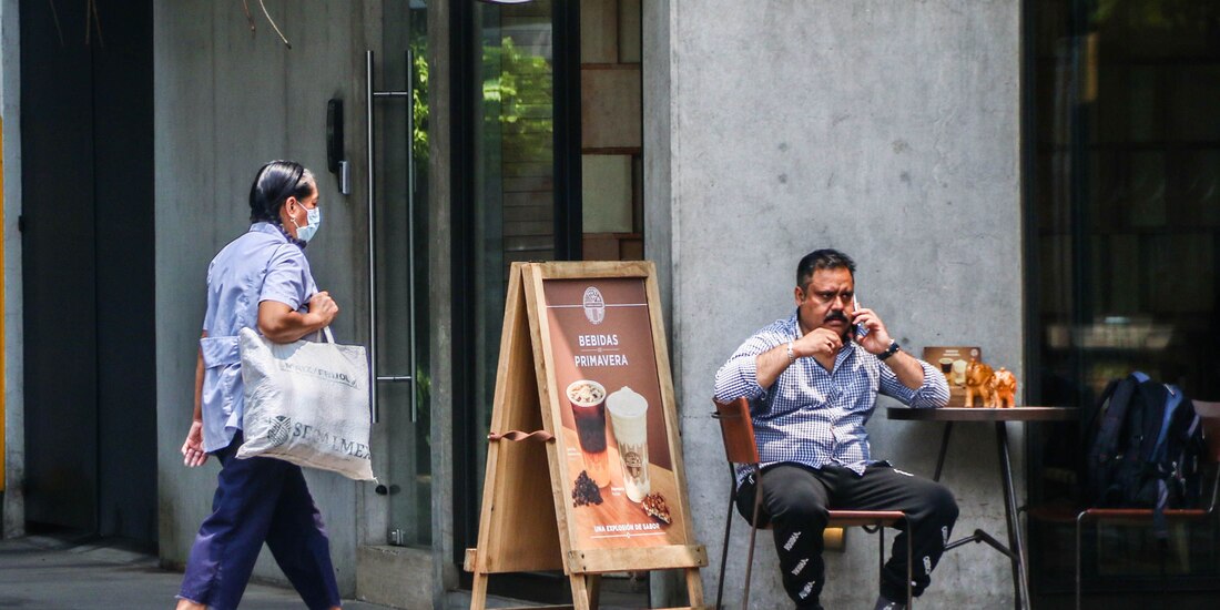 Un hombre habla por teléfono mientras espera en un café.