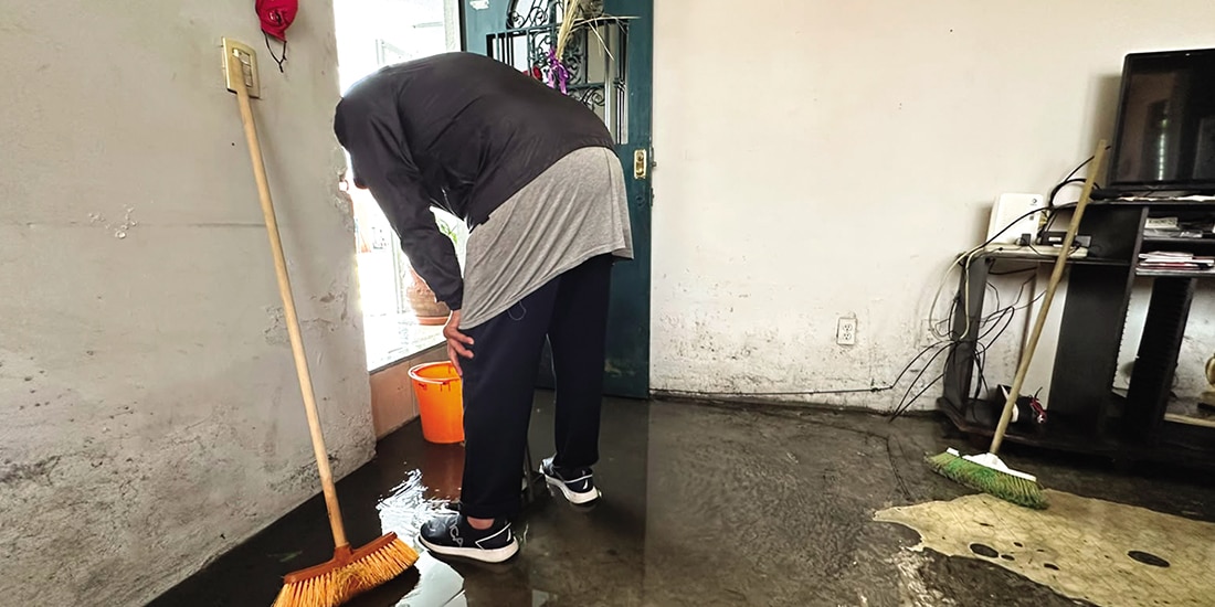 Un hombre recolecta el líquido dentro de su vivienda en una cubeta, ayer.