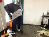 Un hombre recolecta el líquido dentro de su vivienda en una cubeta, ayer.