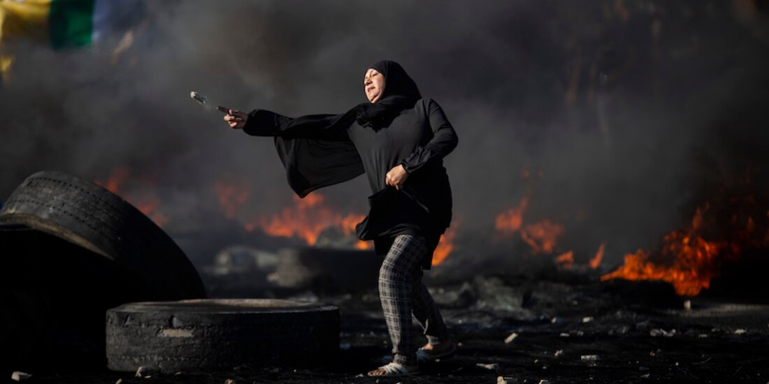 Palestinos se enfrentan con fuerzas israelíes en el puesto de control de Hawara, ayer.