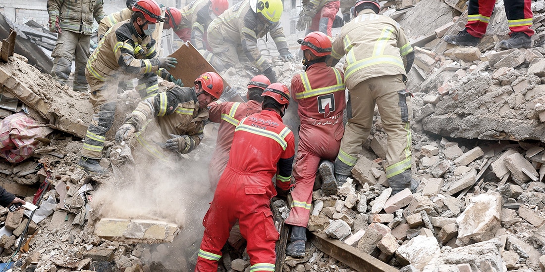 EQUIPOS de rescate buscan super- vivientes entre los escombros tras un ataque en el sur de la capital iraní, ayer.