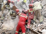 EQUIPOS de rescate buscan super- vivientes entre los escombros tras un ataque en el sur de la capital iraní, ayer.
