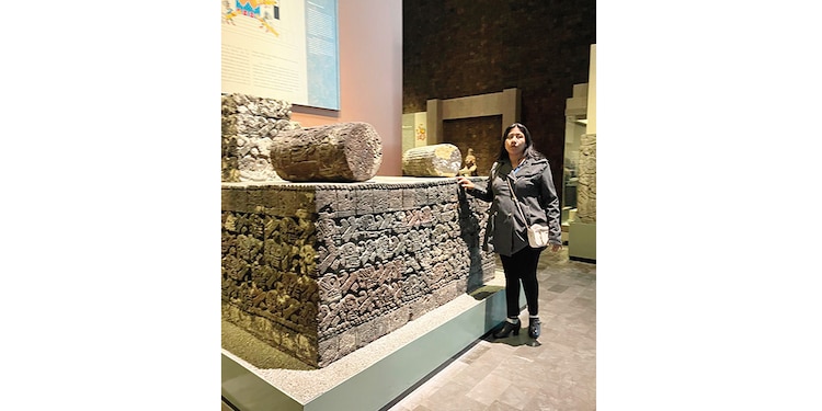 Una señora toca una réplica al posar para una foto.