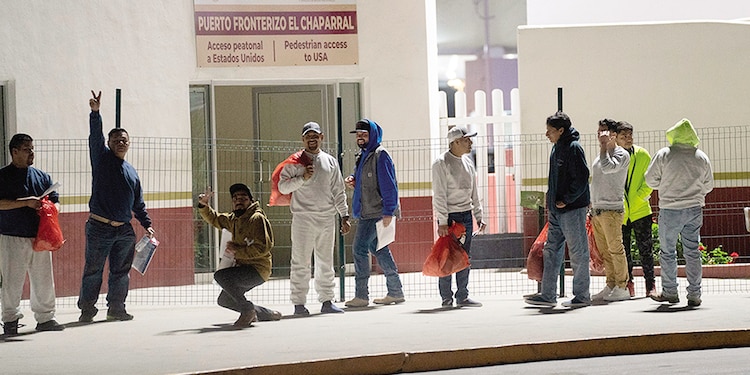 Migrantes deportados de EU, en el puente El Chaparral, en Tijuana, en enero.