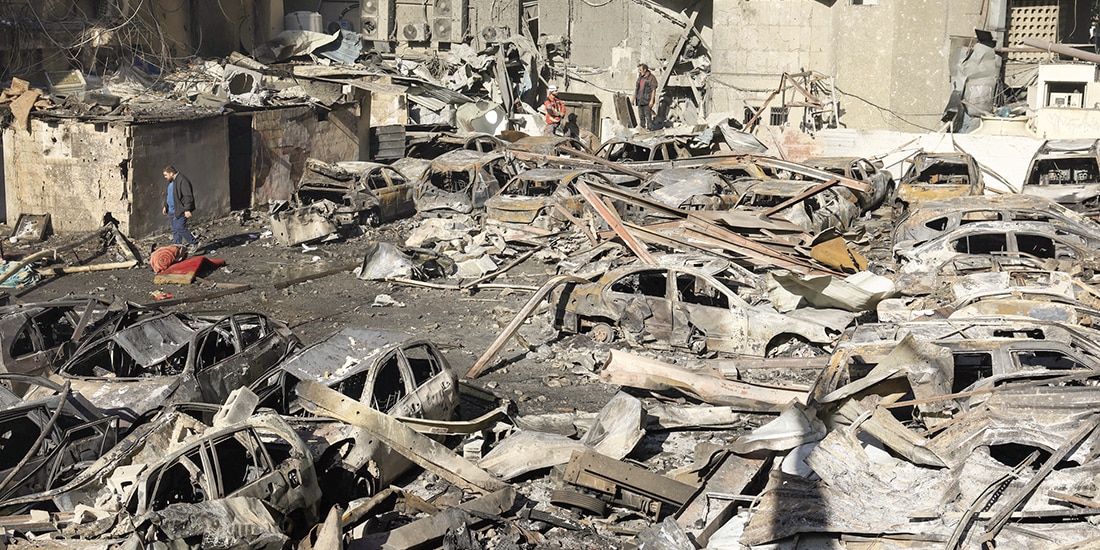 Gente camina entre coches quemados en Al-Mazraa en Beirut, ayer.