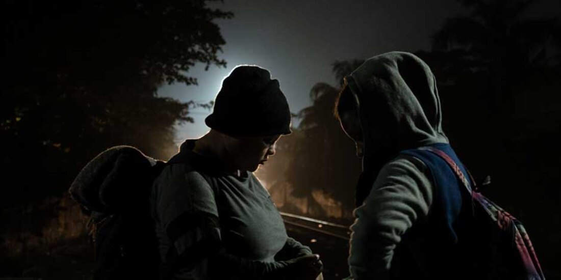 Migrantes a contraluz, en espera del tren conocido como "La Bestia"