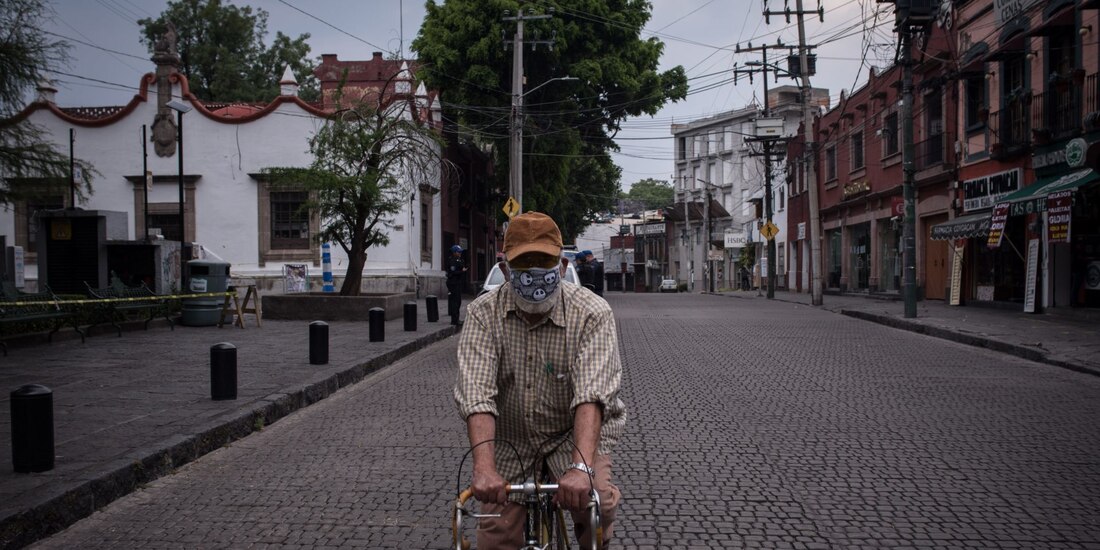Un hombre circula en bicicleta y con cubrebocas en Coyoacán.