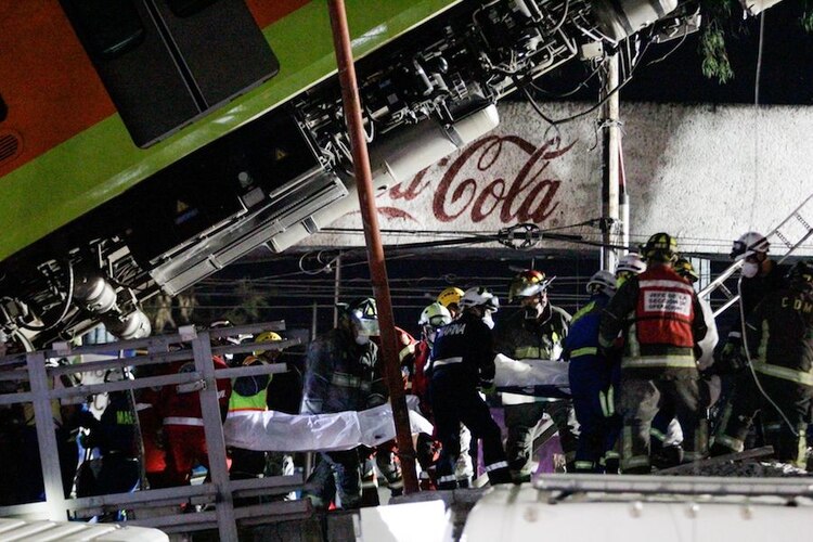 Bomberos retiran cuerpos del lugar del accidente, donde fallecieron más de 20 personas el lunes por la noche.