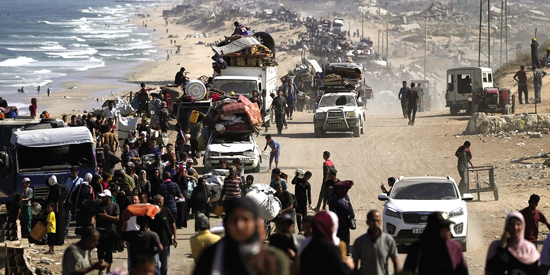 Palestinos desplazados huyen de la capital a pie y en vehículos, cargando con sus pertenencias por la carretera costera hacia el sur de Gaza, ayer.