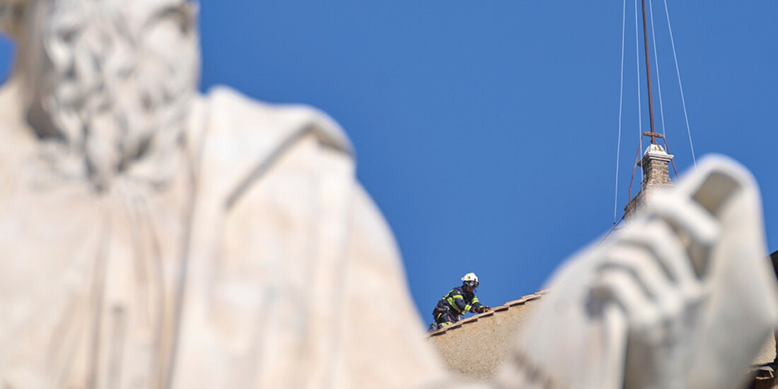 Bomberos colocan la chimenea, ayer, en la Capilla Sixtina.