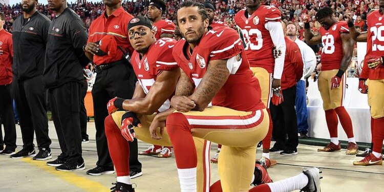 El mariscal de campo se arrodilla durante el himno de Estados Unidos.