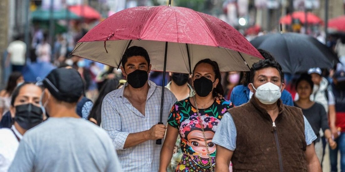 Transeúntes se desplazan sobre las calles del centro histórico mientras se registran ligeras lluvias en la CDMX. 