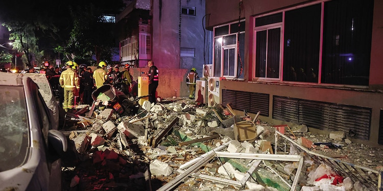 Personal de emergencia inspecciona daños en un edificio en el centro de Israel, ayer.