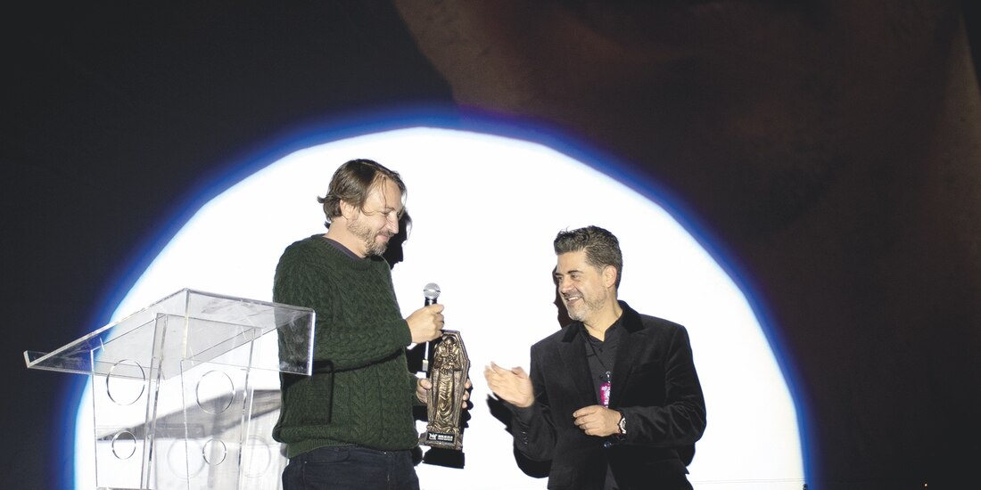 Miguel Ángel Marín, director de Feratum, entrega un reconocimiento por trayectoria al productor Nicolás Celis.