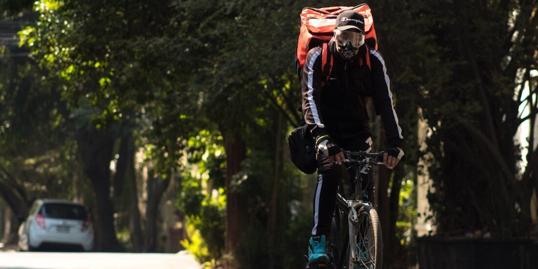 Un joven lleva comida a un domicilio de la colonia Roma.
