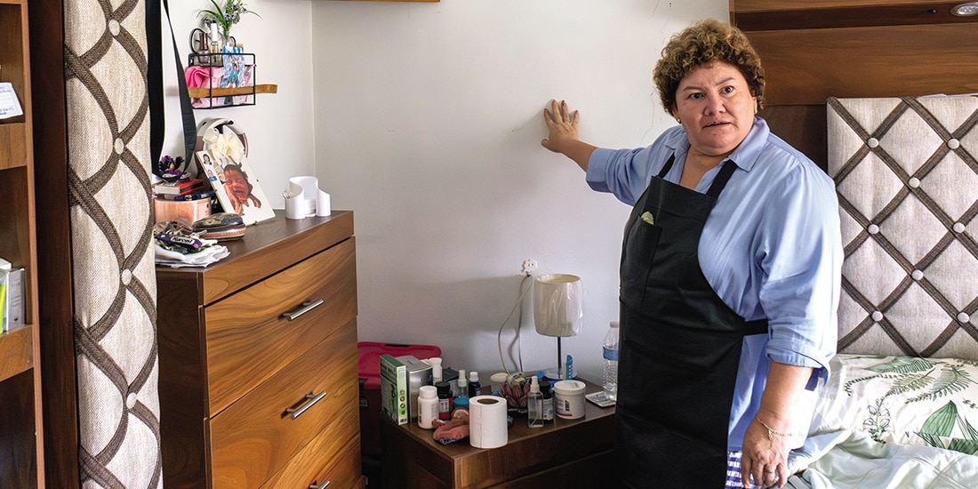 Norma trujillo muestra las grietas que hay en la pared de su habitación, ayer.