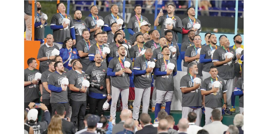 Peloteros de Venezuela cantan el himno en su festejo en Miami, anoche.