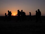Migrantes caminan en Peñitas, Texas.