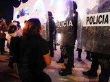Mujeres protestan frente a policías luego de los actos de represión contra una movilización en Cancún.