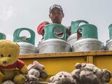 Un repartidor de gas en el barrio de Tepito cuelga monos de peluche en su camión