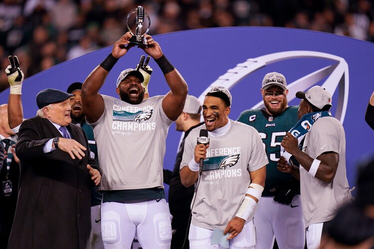 Jugadores de Philadelfia levantan el trofeo que los acredita como campeones.