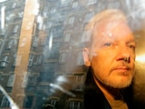 En esta imagen del 1 de mayo de 2019, las fachadas de los edificios se reflejan en una ventana mientras el fundador de WikiLeaks Julian Assange es retirado de una corte en Londres.