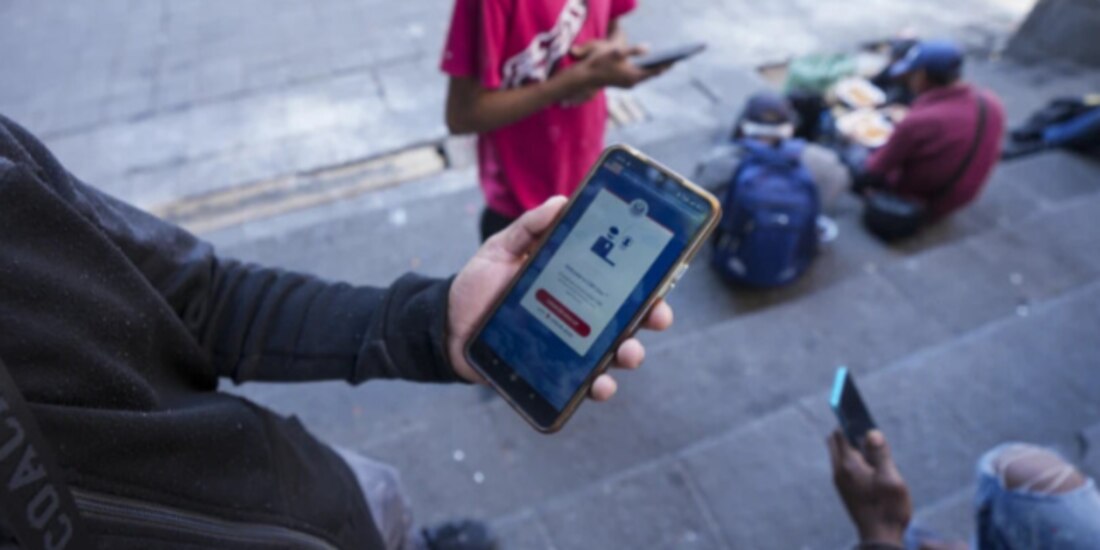 Migrantes con la aplicación CBP One, rebautizada como CBP Home.