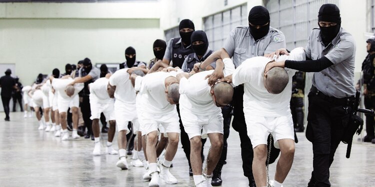 Guardias trasladan a presuntos pandilleros al Cecot, en El Salvador, el domingo.