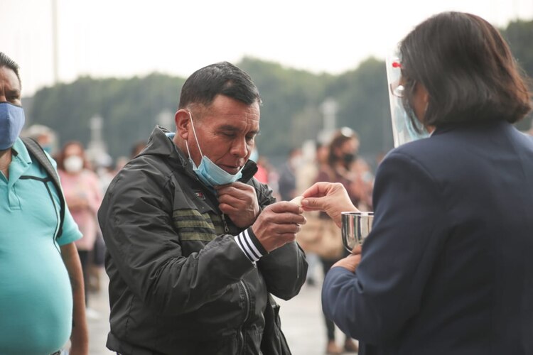 Los fieles reciben la hostia en la mano, para evitar contagio