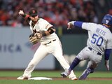 El campocorto de los Giant, Brandon Crawford, lanza a la primera base después de forzar a Mookie Betts (50), de los Dodgers, a salir en segunda durante la primera entrada.