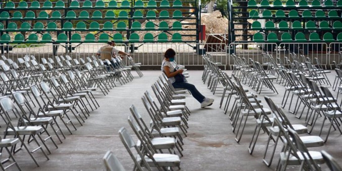 Una persona espera sola en el área de observación, tras recibir una dosis de la vacuna contra COVID-19.