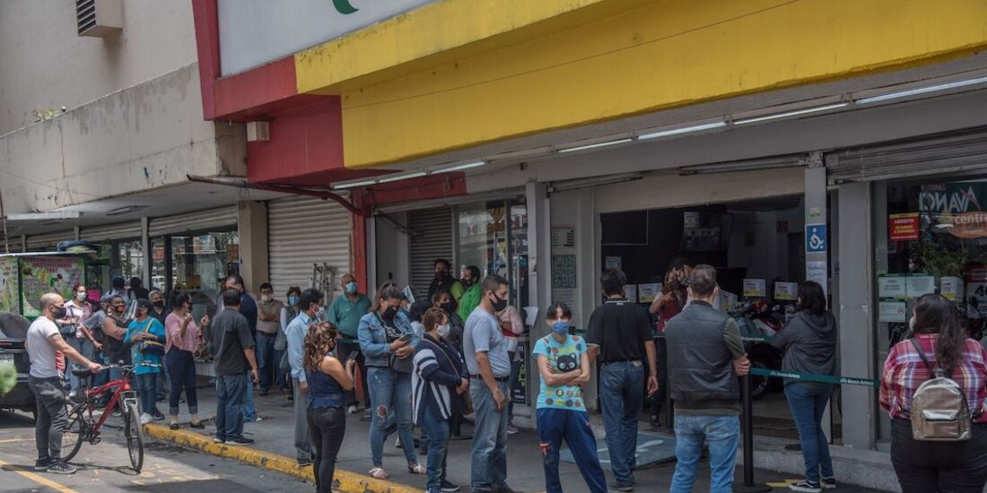 Personas esperan en largas filas para poder ingresar a una tienda de venta de artículos por crédito