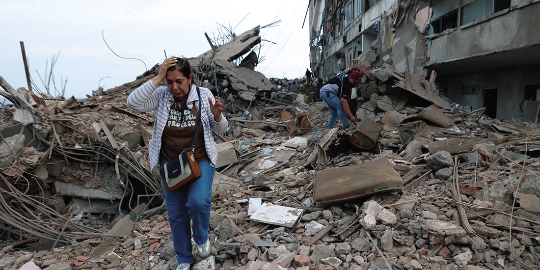 Residentes caminan sobre ruinas de edificios en Catia La Mar, ayer.