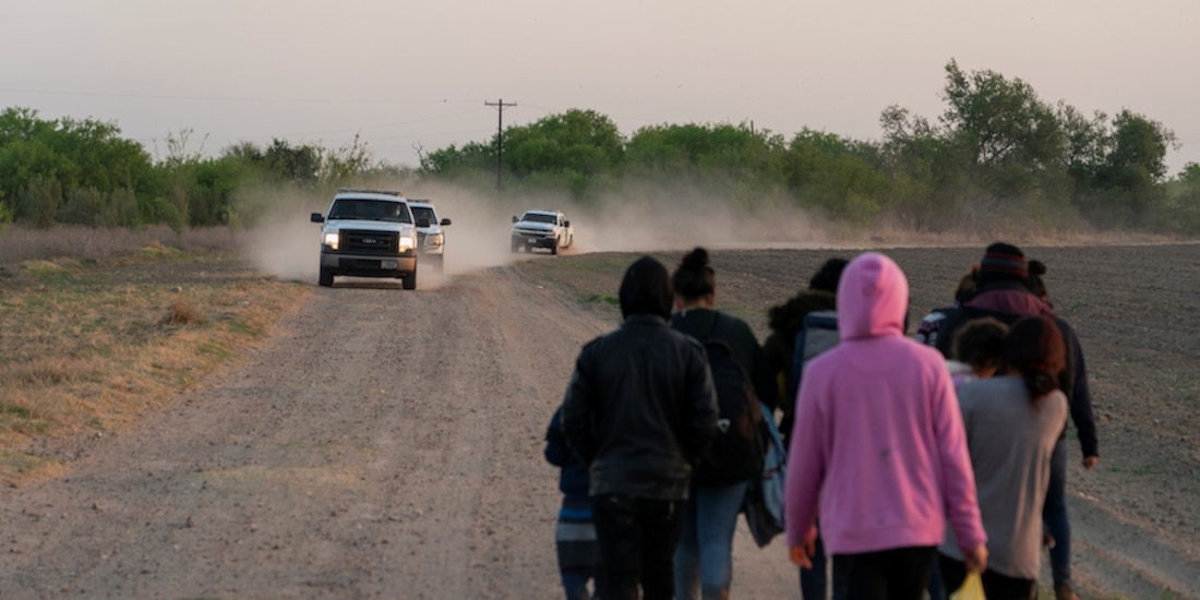Vehículos de la Patrulla Fronteriza se aproximan a migrantes en Peñitas, Texas.