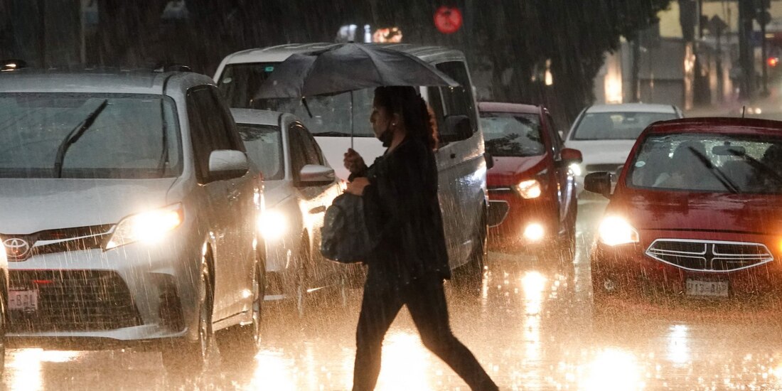 Una mujher con paraguas camina bajo la lluvia en calles de la CDMX, el 11 de mayo de 2023