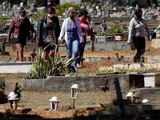 Familiares de una víctima del coronavirus acuden al entierro en Brasilia, ayer.
