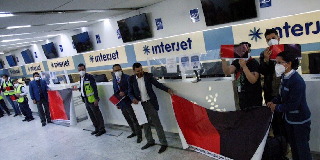 Trabajadores colocan banderas de huelga en edificio de Interjet, ayer.